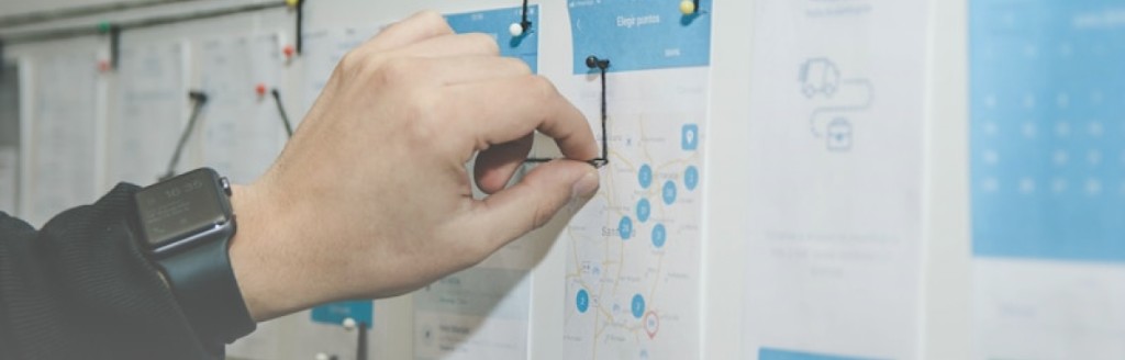 Hand pinning product planning mockups to a board